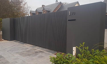 Moderne schuifpoort met verticale kokers en vaste panelen - Faimes