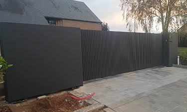 Moderne schuifpoort met verticale kokers en vaste panelen - Faimes